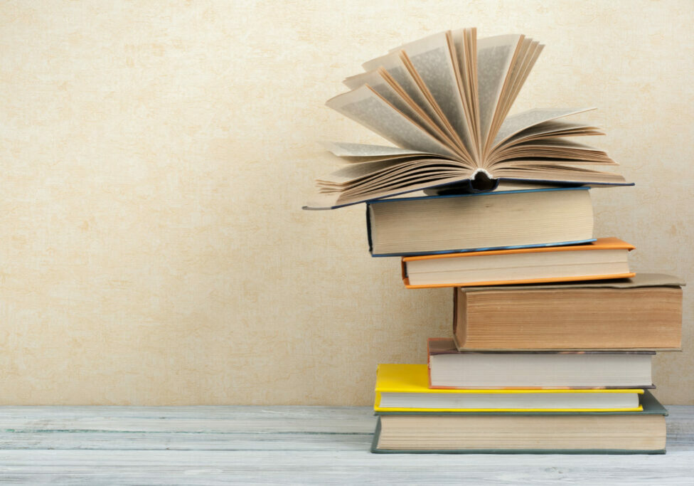 Stack of colorful books. Education background. Back to school. Book, hardback colorful books on wooden table. Education business concept. Copy space for text.